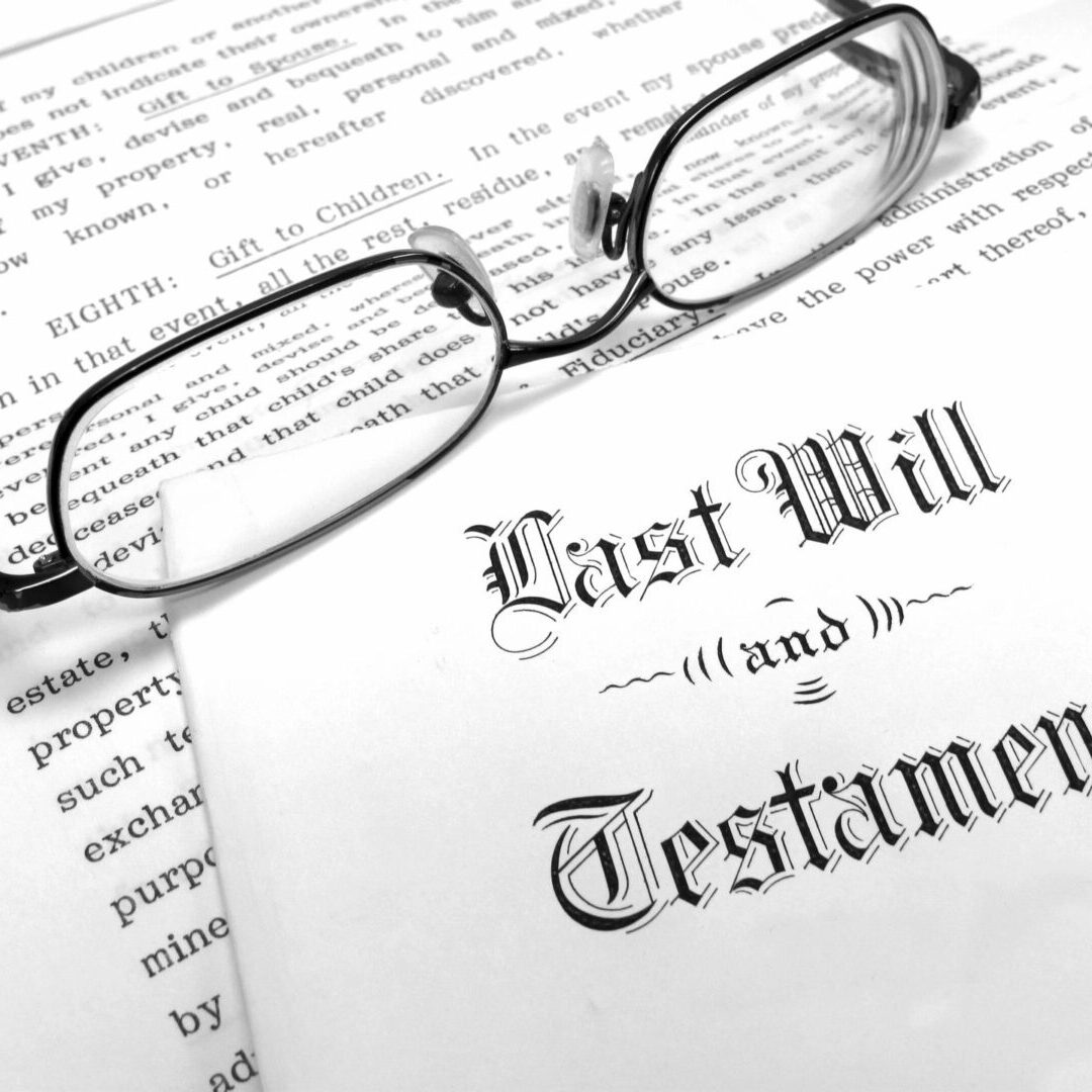 A pair of eyeglasses rests on top of documents, with "Last Will and Testament" prominently displayed.